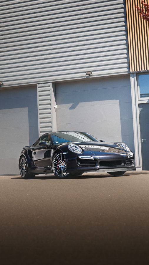 Porsche 911 devant un atelier