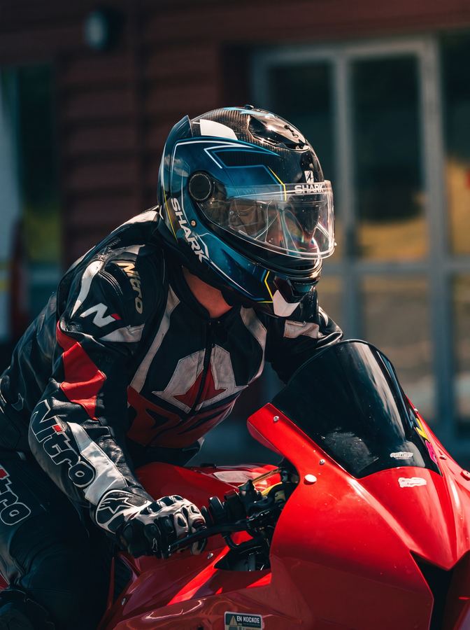 Pilote casqué sur une moto rouge